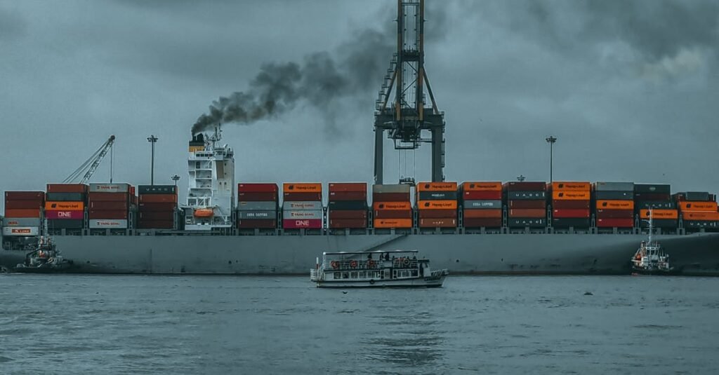 A cargo ship emitting smoke in a harbor through its scrubber which is a open loop and closed loop scrubber.